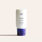 White Reactivating Hand Cream bottle with purple cap on a pale background